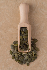 Image showing Wooden scoop with pumpkin seeds