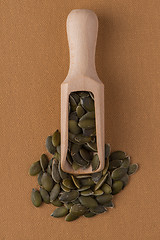 Image showing Wooden scoop with pumpkin seeds