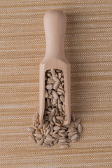 Image showing Wooden scoop with shelled sunflower seeds