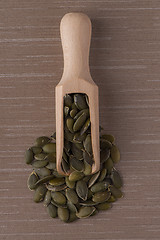 Image showing Wooden scoop with pumpkin seeds