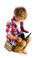 Image showing boy with a Tablet PC sitting on the books