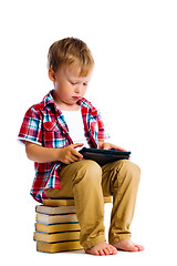 Image showing boy with a Tablet PC sitting on the books