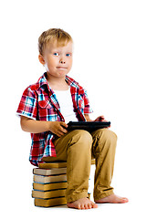 Image showing boy with a Tablet PC sitting on the books