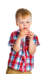 Image showing little boy stands and examines small toy
