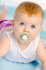 Image showing Beautiful baby with a pacifier. Close-up. Studio photo