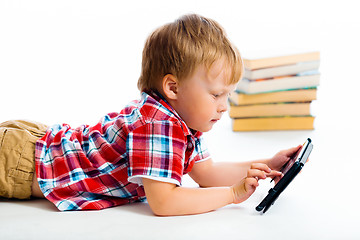 Image showing small boy with tablet computer lying on the floor