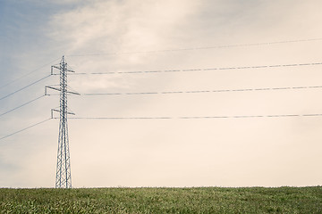 Image showing Tall pylons on a green field