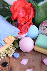 Image showing Towels with lily, aroma oil,  candles and sea salt on wooden plate