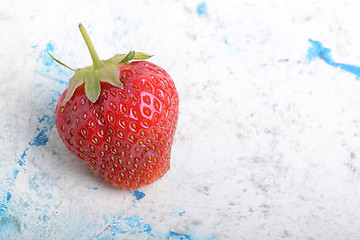 Image showing Close-up detail of a fresh red strawberry with leaves