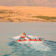 Image showing Kids tube riding tawed by speedboat.