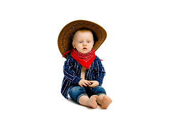 Image showing boy in a cowboy hat sitting on a white floor