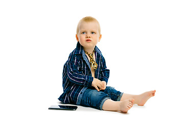 Image showing boy in a tie sitting on a white floor