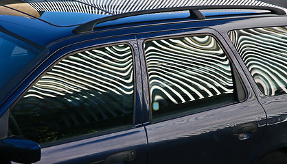 Image showing Car and stripes, car parked in front of a building with striped 