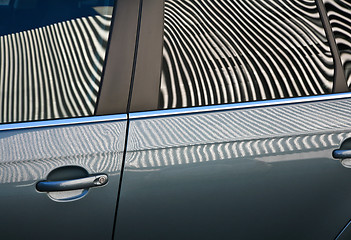 Image showing Car and stripes, car parked in front of a building with striped 