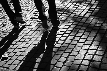 Image showing Walking legs on pavement in the sun, with shades