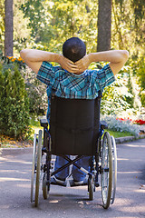 Image showing young man in a wheelchair enjoying fresh air on a sunny day