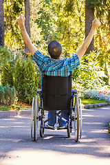 Image showing young man in wheelchair with wide opened arms