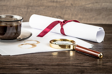 Image showing Coffee cup, paper sheets and detective magnifying glass