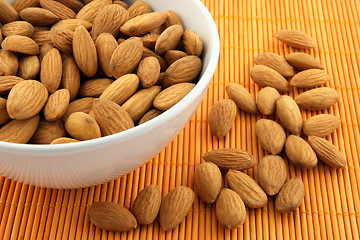 Image showing Bowl of almonds on rattan mat