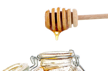 Image showing Jar of honey with wooden drizzler