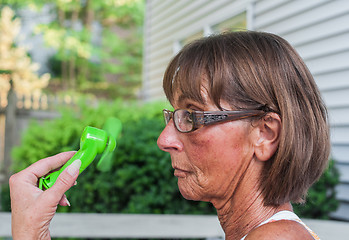 Image showing Woman Cools Herself