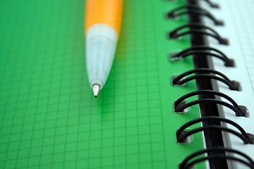 Image showing Orange ballpoint pen on notebook