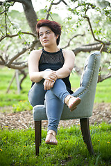 Image showing Brunette Woman on a Chair Outside