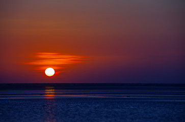 Image showing Orange Ball of the Sun Dipping towards Horizon at Sunset