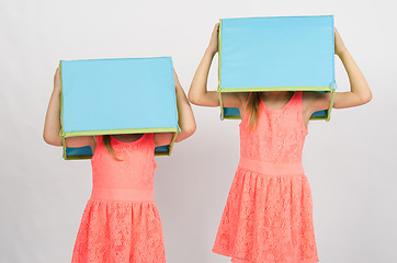 Image showing Two girls with boxes on their heads