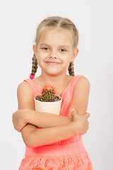 Image showing Happy little girl hug pot of cactus