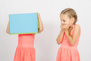 Image showing The girl was frightened other girl with a box on his head