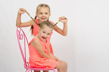 Image showing Girl having fun with pigtails sister