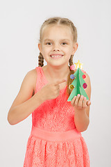 Image showing Happy girl showing on the Christmas tree made of cardboard