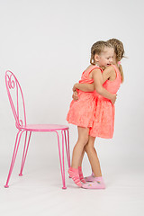 Image showing Girl trying to sit on a chair his sister