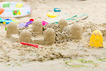 Image showing Sand castle circle and toys on the river bank