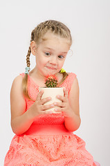 Image showing The girl stares at a cactus in pot