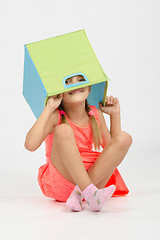 Image showing Girl indulging in a box for toys put on the head