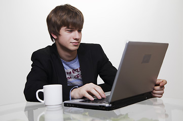 Image showing confident young manager at work with laptop