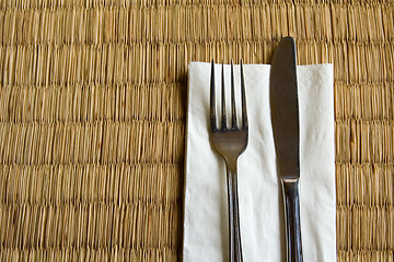Image showing Fork and knife on a dried grass mat

