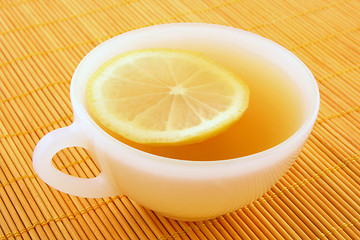 Image showing Cup of tea with lemon in warm golden light
