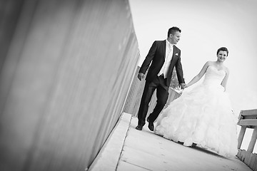 Image showing Bride and groom walking in city bw