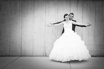 Image showing Bride and groom spreading arms bw