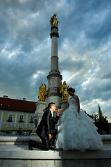 Image showing Bride and groom posing in front of city fountain
