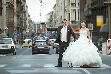 Image showing Newlyweds standing on pedestrian crossing