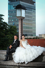 Image showing Newlyweds sitting next to street lamp