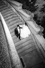 Image showing Newlyweds walking down stone steps bw