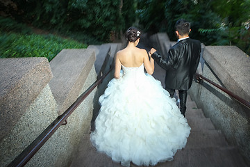 Image showing Newlyweds walking down stone stairs