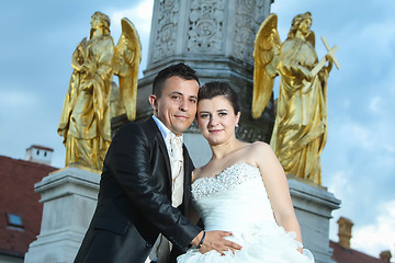 Image showing Bride and groom posing in front of fountain