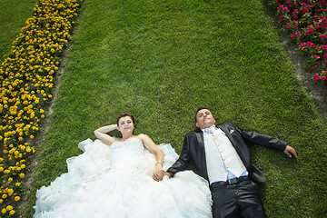 Image showing Bride and groom on lawn with flowers