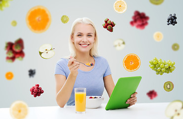 Image showing smiling woman with tablet pc eating breakfast